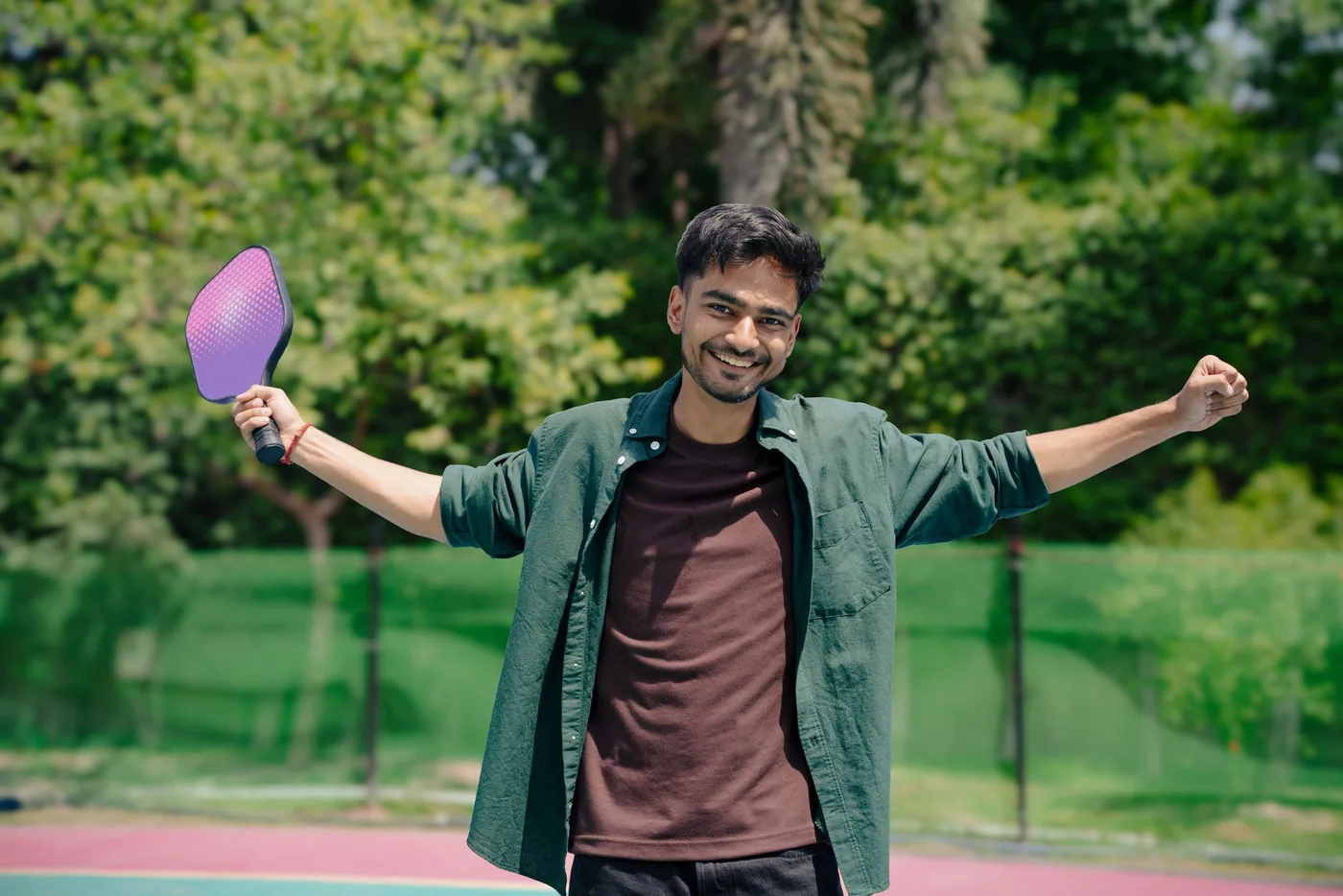 Player celebrating on a pickleball court, paddle raised